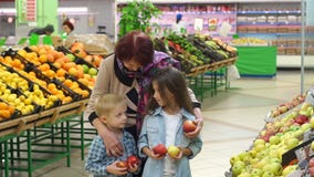 S?odka mi?a babcia z ma?ymi dzie?mi kupuje ?wie?ych jab?ka w supermarkecie zbiory wideo S?odka mi?a babcia z ma?ymi dzie?mi kupuje ?wie?ych jab?ka w supermarkecie zbiory wideo