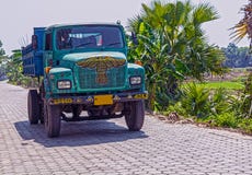 Sable fonctionnant et de transport de camion de déchargeur indien coloré pour des travaux de construction image stock Sable fonctionnant et de transport de camion de déchargeur indien coloré pour des travaux de construction image stock