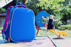Sac d'?cole et un ?tudiant ?l?mentaire sur le terrain de jeu photos libres de droits Sac d'?cole et un ?tudiant ?l?mentaire sur le terrain de jeu photos libres de droits