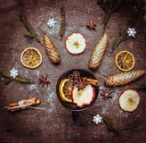Sacador caliente del vino en taza oscura con las especias y las frutas del invierno en la tabla de madera foto de archivo libre de regalías Sacador caliente del vino en taza oscura con las especias y las frutas del invierno en la tabla de madera foto de archivo libre de regalías