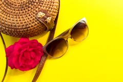 Saco do verão das mulheres à moda da palha e óculos de sol e uma flor cor-de-rosa vermelha em um fundo amarelo Conceito das f?ria imagens de stock Saco do verão das mulheres à moda da palha e óculos de sol e uma flor cor-de-rosa vermelha em um fundo amarelo Conceito das f?ria imagens de stock