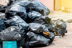 Sacos de lixo pretos na rua da cidade, gestão de resíduos em grandes cidades imagem de stock Sacos de lixo pretos na rua da cidade, gestão de resíduos em grandes cidades imagem de stock