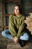 Sad brown haired dreamy model girl sitting cross-legged yoga style on wooden background floor. royalty free stock photography Sad brown haired dreamy model girl sitting cross-legged yoga style on wooden background floor. royalty free stock photography