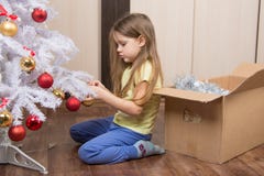 Sad girl removes a Christmas tree with toys stock image Sad girl removes a Christmas tree with toys stock image