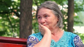 Sad old woman in the park
