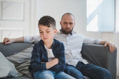 A sad and resentful boy and an angry father in the background. stock image A sad and resentful boy and an angry father in the background. stock image