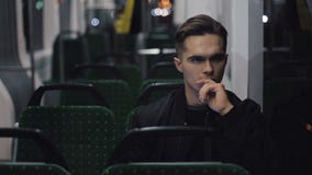Sad unhappy man riding tram through the city at night. Depressed look of a young man in empty transport stock video footage Sad unhappy man riding tram through the city at night. Depressed look of a young man in empty transport stock video footage