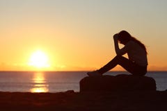 Sad woman silhouette worried on the beach