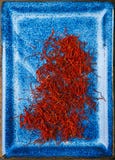 Saffraan ruimtedraden in blauwe plaatkom royalty-vrije stock afbeelding Saffraan ruimtedraden in blauwe plaatkom royalty-vrije stock afbeelding