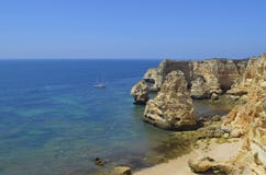 Sailboat στην εγκαταλειμμένους παραλία και τους απότομους βράχους στοκ φωτογραφία Sailboat στην εγκαταλειμμένους παραλία και τους απότομους βράχους στοκ φωτογραφία