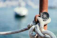 Sailing: nautical compass on a sailing rope, pier. Sailing boats in the background stock photos Sailing: nautical compass on a sailing rope, pier. Sailing boats in the background stock photos