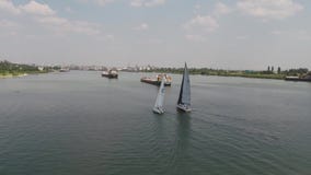 Sailing yacht on big river. Three yachts cruise on river. Yachts race on the lake. stock footage Sailing yacht on big river. Three yachts cruise on river. Yachts race on the lake. stock footage