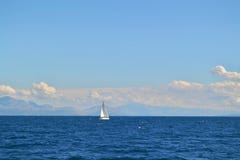 Sailing yacht and the sea. Land outline in the distance. royalty free stock image Sailing yacht and the sea. Land outline in the distance. royalty free stock image
