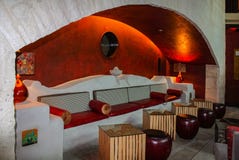 Sala de estar encendida al aire libre en un arco con el banco y tablas y escabeles adornados concretos imágenes de archivo libres de regalías Sala de estar encendida al aire libre en un arco con el banco y tablas y escabeles adornados concretos imágenes de archivo libres de regalías
