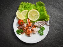 Salada do calamar com as ervas picantes do molho de pimentões e as especiarias - fatia grelhada do calamar na placa no restaurant fotografia de stock Salada do calamar com as ervas picantes do molho de pimentões e as especiarias - fatia grelhada do calamar na placa no restaurant fotografia de stock