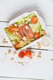 Salade de César avec des poissons dans la boîte sur la surface en bois images libres de droits Salade de César avec des poissons dans la boîte sur la surface en bois images libres de droits