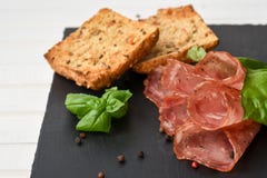 Salami dymiąca kiełbasa pokrajać liście, peppercorns i chleb basilu, zdjęcia royalty free Salami dymiąca kiełbasa pokrajać liście, peppercorns i chleb basilu, zdjęcia royalty free
