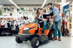 Salesman is showing couple of clients new cleaning machine in power tools store. stock photo Salesman is showing couple of clients new cleaning machine in power tools store. stock photo