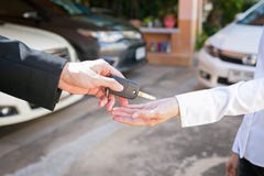 Salesman offering car key to a customers at showroom used car. stock photography Salesman offering car key to a customers at showroom used car. stock photography