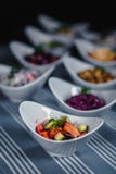 Sallader i vita plattor på tabellen Sallad av nya tomater, gurkor och lökar i förgrunden I det oskarpt royaltyfri bild Sallader i vita plattor på tabellen Sallad av nya tomater, gurkor och lökar i förgrunden I det oskarpt royaltyfri bild