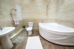 Salle de bains légère et propre avec la toilette avec des tuiles sur le plancher images libres de droits Salle de bains légère et propre avec la toilette avec des tuiles sur le plancher images libres de droits