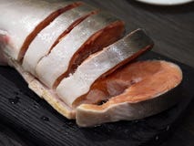 Salmões cor-de-rosa em uma placa de corte, cortando em bifes fotografia de stock Salmões cor-de-rosa em uma placa de corte, cortando em bifes fotografia de stock