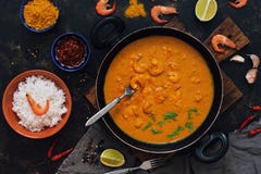 Salsa de curry con los camarones en un sartén Arroz en un cuenco, especias, cal Comida tailandesa, india Visión desde arriba fotografía de archivo Salsa de curry con los camarones en un sartén Arroz en un cuenco, especias, cal Comida tailandesa, india Visión desde arriba fotografía de archivo