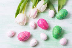 Salutation de Pâques avec les oeufs de tulipes, verts et roses blancs de scintillement image stock Salutation de Pâques avec les oeufs de tulipes, verts et roses blancs de scintillement image stock