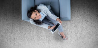 Samengesteld beeld van vrouw op haar tablet die omhoog eruit zien stock foto's Samengesteld beeld van vrouw op haar tablet die omhoog eruit zien stock foto's