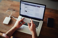 Samiec wręcza trzymać kredytową kartę używać laptop w domu obraz stock Samiec wręcza trzymać kredytową kartę używać laptop w domu obraz stock