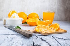Sammanpressad orange fruktsaft och nya apelsiner bär frukt på vit trät arkivfoto Sammanpressad orange fruktsaft och nya apelsiner bär frukt på vit trät arkivfoto