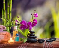 Sammansättningsbrunnsortmassage - bambu - orkidé, handdukar, stearinljus och svartstenar fotografering för bildbyråer Sammansättningsbrunnsortmassage - bambu - orkidé, handdukar, stearinljus och svartstenar fotografering för bildbyråer