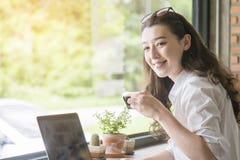 Sammantr?de f?r ung kvinna i coffee shop p? tr?tabellen som dricker kaffe och anv?nder smartphonen P? tabellen ?r b?rbara datorn arkivbilder Sammantr?de f?r ung kvinna i coffee shop p? tr?tabellen som dricker kaffe och anv?nder smartphonen P? tabellen ?r b?rbara datorn arkivbilder