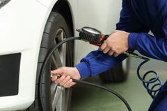 Samochodowy mechanik sprawdza opona lotniczego naciska obraz stock Samochodowy mechanik sprawdza opona lotniczego naciska obraz stock