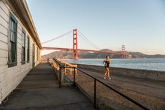 SAN FRANCISCO, DE V.S. - 12 OKTOBER, 2018: Vrouw die dichtbij Fortpunt lopen met Golden gate bridge op de achtergrond royalty-vrije stock foto SAN FRANCISCO, DE V.S. - 12 OKTOBER, 2018: Vrouw die dichtbij Fortpunt lopen met Golden gate bridge op de achtergrond royalty-vrije stock foto