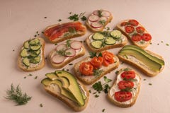 Sandu?ches com salm?es, pepino, tomates, abacates e verdes, vegetal cortado fotografia de stock Sandu?ches com salm?es, pepino, tomates, abacates e verdes, vegetal cortado fotografia de stock