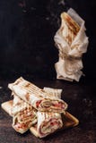 Sanduíche de Shawarma - um rolo fresco do lavash fino, enchido com a carne, os cogumelos, o queijo e as ervas grelhados Petisco o fotografia de stock Sanduíche de Shawarma - um rolo fresco do lavash fino, enchido com a carne, os cogumelos, o queijo e as ervas grelhados Petisco o fotografia de stock