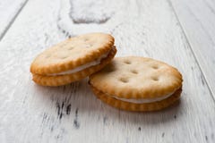 Sandwichkoekjes met het witte room vullen op wit hout Stock Afbeelding Sandwichkoekjes met het witte room vullen op wit hout Stock Afbeelding
