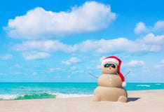 Sandy Snowman in Christmas Santa hat and sunglasses at beach royalty free stock image Sandy Snowman in Christmas Santa hat and sunglasses at beach royalty free stock image