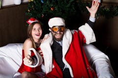 Santa Claus brutal con la mujer atractiva de la enfermera de sexo femenino en el traje del carnaval, conduciendo en el sofá tiene foto de archivo libre de regalías Santa Claus brutal con la mujer atractiva de la enfermera de sexo femenino en el traje del carnaval, conduciendo en el sofá tiene foto de archivo libre de regalías
