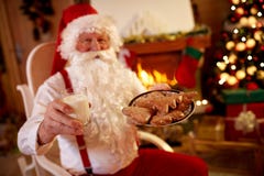 Santa Claus, die im traditionellen Weihnachtssnack genießt lizenzfreies stockfoto Santa Claus, die im traditionellen Weihnachtssnack genießt lizenzfreies stockfoto