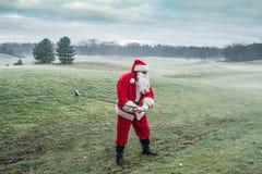 Santa Claus on the winter golf course plays golf. Christmas and new year