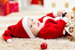 Santa weared bebê que guarda a bola do Natal foto de stock Santa weared bebê que guarda a bola do Natal foto de stock