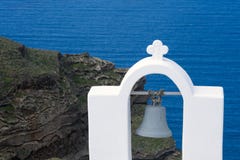 Santorini, Gr?cia, em abril de 2019 Ab?bada e sino brancos em um fundo do mar azul, de uma ilha e de um vulc?o imagem de stock Santorini, Gr?cia, em abril de 2019 Ab?bada e sino brancos em um fundo do mar azul, de uma ilha e de um vulc?o imagem de stock