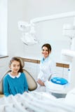 Santé dentaire Dentiste And Happy Girl dans le bureau d'art dentaire photographie stock Santé dentaire Dentiste And Happy Girl dans le bureau d'art dentaire photographie stock