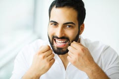 Santé dentaire Homme avec le beau sourire Flossing les dents saines photos stock Santé dentaire Homme avec le beau sourire Flossing les dents saines photos stock