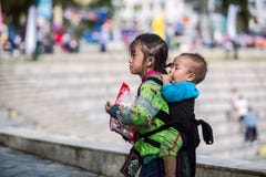 SAPA, VIETNAME - 3 DE SETEMBRO DE 2017: Moça asiática que leva seu irmão na rua na cidade do sapa fotos de stock SAPA, VIETNAME - 3 DE SETEMBRO DE 2017: Moça asiática que leva seu irmão na rua na cidade do sapa fotos de stock