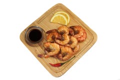 Sauce grillée au Roi Size Shrimps With servie sur le conseil en bois photos libres de droits Sauce grillée au Roi Size Shrimps With servie sur le conseil en bois photos libres de droits