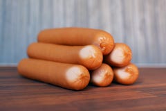 Saucisses de Francfort multiples empilées sur la table en bois image stock Saucisses de Francfort multiples empilées sur la table en bois image stock