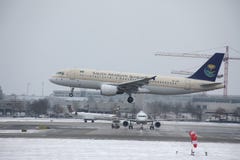 Saudi Arabian Airlines Airbus A320-200 HZ-ASB landing on snowy runway Stock Photography Saudi Arabian Airlines Airbus A320-200 HZ-ASB landing on snowy runway Stock Photography